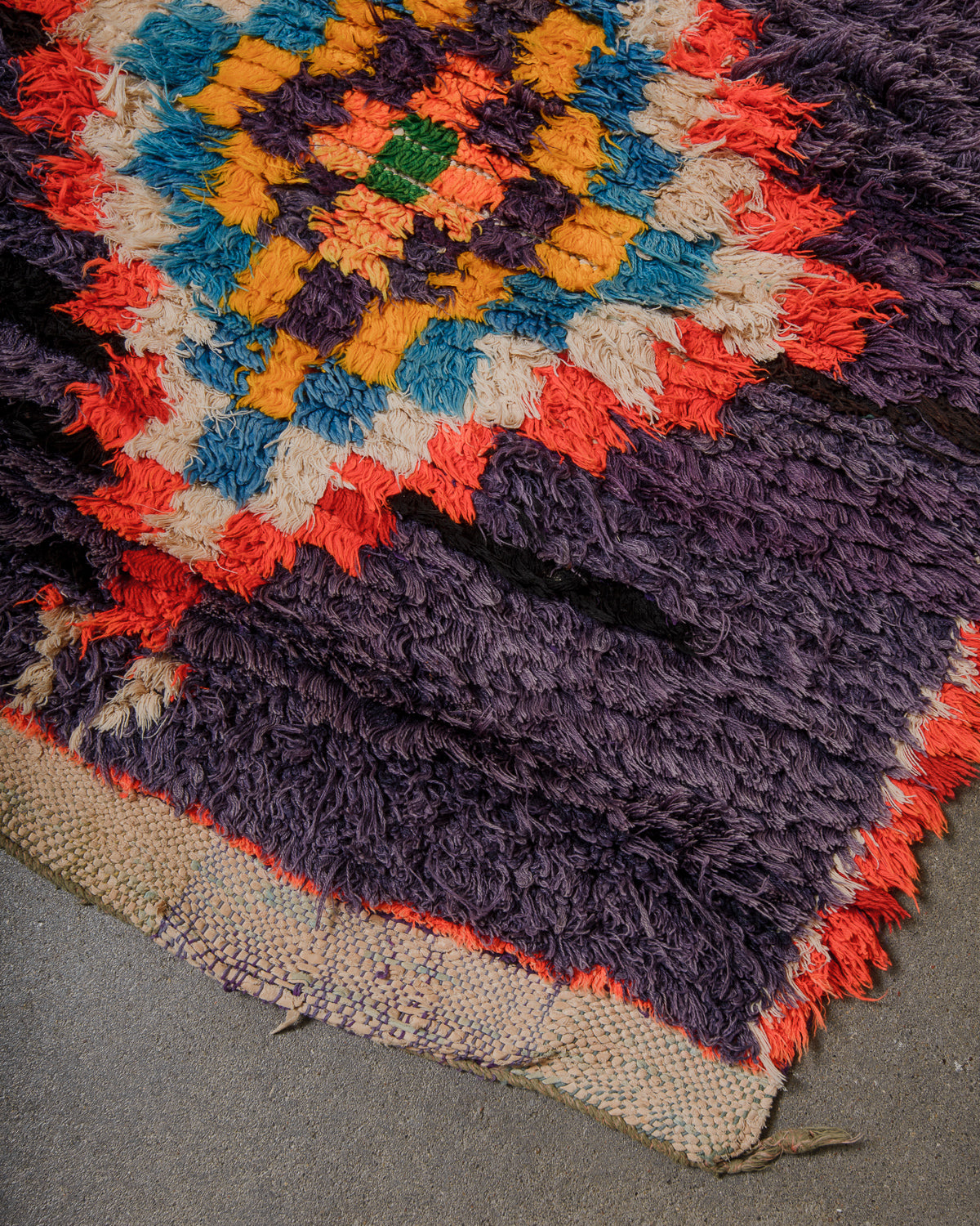 Multicolored textured rug with a geometric pattern on a gray surface